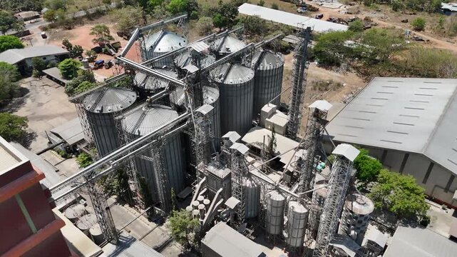 Aerial view of a large industrial grain elevator complex with metal storage silos for agriculture