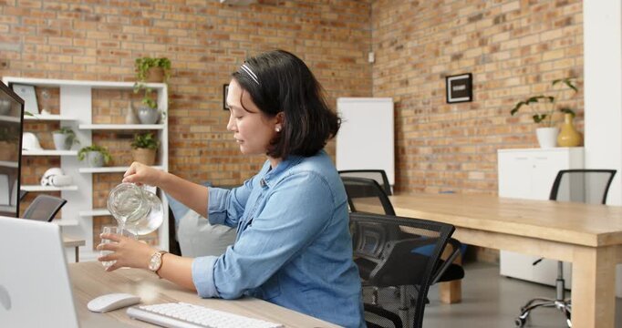 Lifestyle videos indoor of people doing activities at office, working at desk, woman drinking water