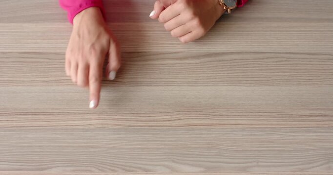 Close up of people talking to the camera, pointing at wooden table, person in pink sleeve gesturing