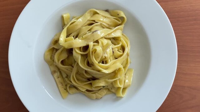Italian egg pappardelle pasta served with creamy mushroom sauce on plate. Pappardelle ai funghi porcini.