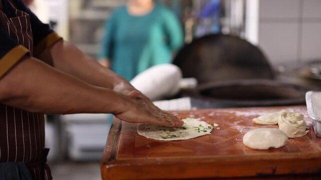 Chef Preparing Fresh Garlic Naan Flatbread in Traditional Kitchen