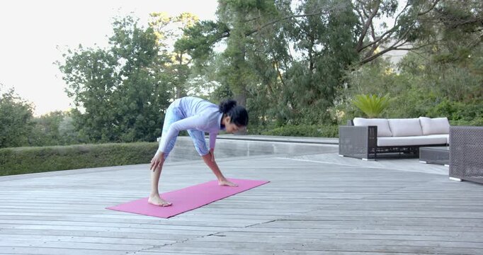 Lifestyle videos outdoor of people doing activities , practicing yoga on pink mat, woman stretching