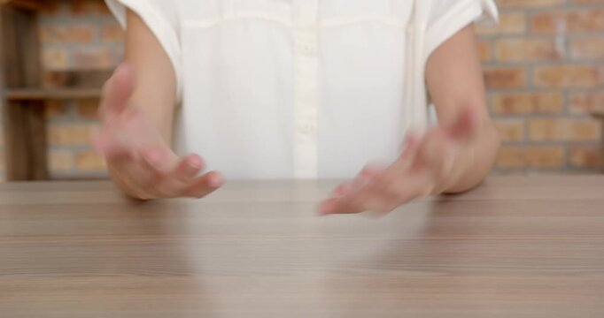 Close up of people talking to the camera, clasping hands together, person sitting at wooden desk