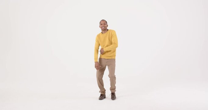 High-speed photography for dynamic scenes, smiling man in yellow sweater dancing joyfully in casual