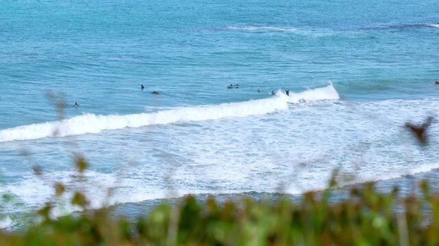High angle view of surfers riding waves off Flysch cliffs Spain