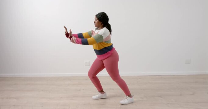 High speed photography for dynamic scenes, Woman in colorful sweater and pink leggings dancing in.