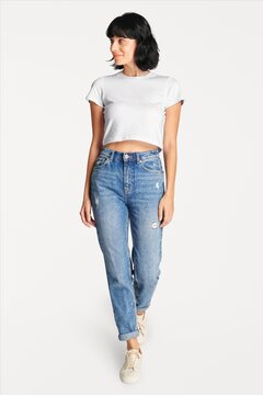 Casual young woman in white crop top and jeans on white background