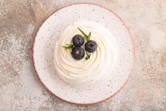 Pavlova Meringue dessert with crisp meringue on brown concrete, close up, top view
