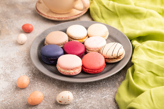 Macarons colourful cookies dessert on brown concrete, close up, side view