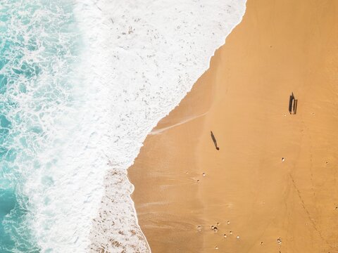 Aerial top down view Gjipe Beach with woman walking enjoy relax on sandy shore while clear turquoise waves of Ionian sea crash close