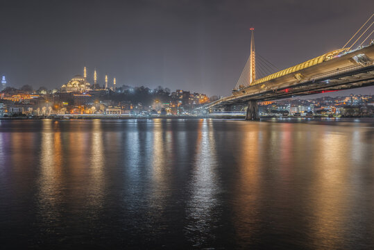 View of the illuminated Suleymaniye Mosque and the modern Halic Metro Bridge spanning the Golden Horn at night in Istanbul, Istanbul, Turkiye.