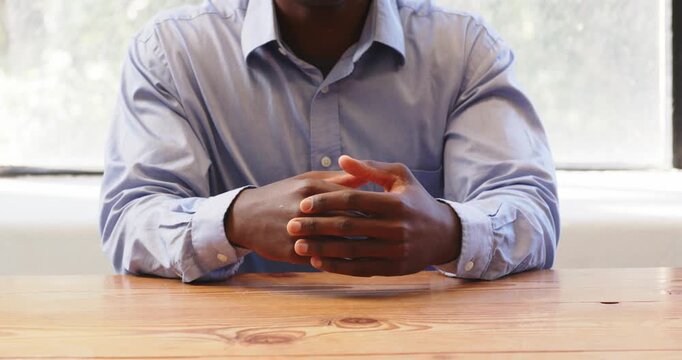 Business professional gesturing during meeting at office, wearing blue shirt