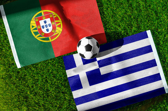 Portugal vs. Greece football match. National flags on green grass with soccer ball in the middle. Football background for international match.