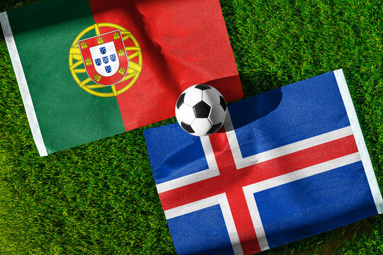 Portugal vs. Iceland football match. National flags on green grass with soccer ball in the middle. Football background for international match.