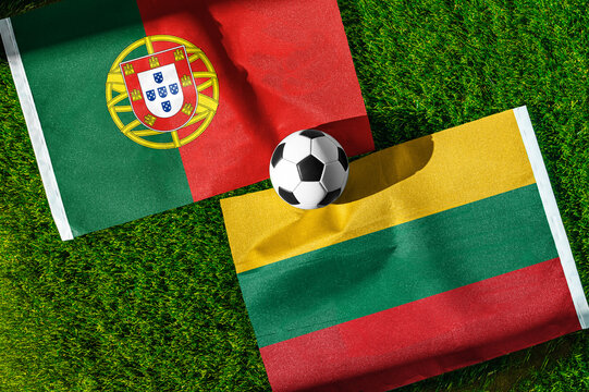 Portugal vs. Lithuania football match. National flags on green grass with soccer ball in the middle. Football background for international match.