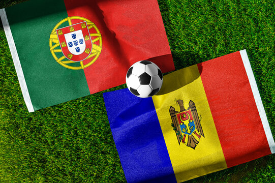 Portugal vs. Moldova football match. National flags on green grass with soccer ball in the middle. Football background for international match.