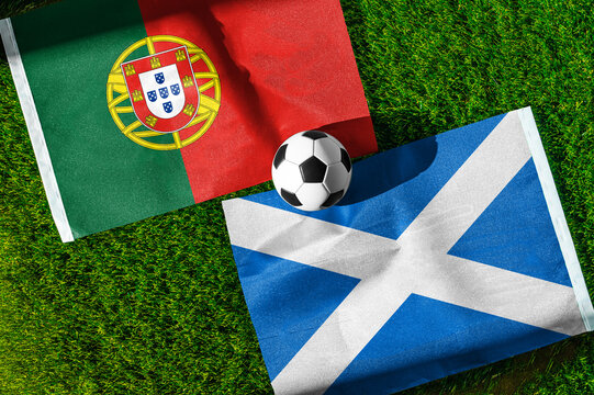 Portugal vs. Scotland football match. National flags on green grass with soccer ball in the middle. Football background for international match.