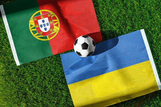 Portugal vs. Ukraine football match. National flags on green grass with soccer ball in the middle. Football background for international match.