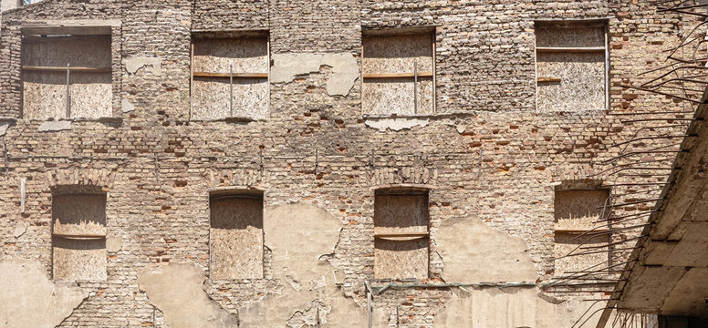 Old brick building facade with boarded up windows