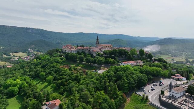 aerial drone view of Buzet historic medieval town in Istria Croatia at early summer showing old stone buildings, hilltop settlement, surrounding forests and green valley landscape