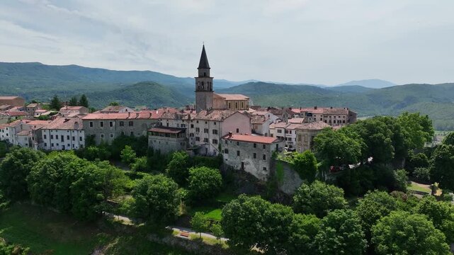 aerial drone view of Buzet historic medieval town in Istria Croatia at early summer showing old stone buildings, hilltop settlement, surrounding forests and green valley landscape
