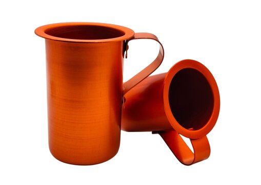 Photo of two traditional Greek orange anodized aluminum wine pitchers (oinometro), commonly used in tavernas to serve house wine, isolated on white background.