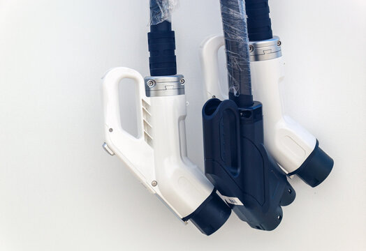 Detailed close up of new electric car charging plugs wrapped in protective plastic film with copy space