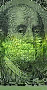 Benjamin Franklin on 100 Dollar Bill with Green Scan. Benjamin Franklin portrait on 100 dollar bill glows under moving green security scan. Banknote image shifts from top to bottom.