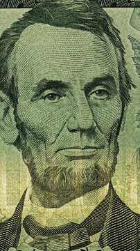 Five dollar bill security light over Lincoln portrait. Abraham Lincoln portrait on five dollar bill shifts under smooth green light scan. 