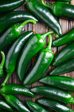 Heap of green mexican jalapeno hot peppers close up. Top view. Food photography