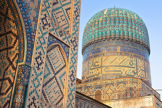 Bibi-Khanym Mosque dome and tilework detail in Samarkand Uzbekistan. Intricate geometric and calligraphic mosaic patterns adorn the turquoise ribbed dome and facade. Ideal for travel publications.