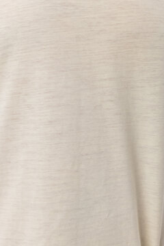 Close-up macro texture of soft cream beige knit fabric. Detailed view of natural cotton heathered textile background. Perfect for clothing, fashion, and seamless pattern design mockups.