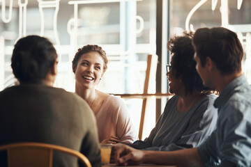 Fototapeta premium Woman, friends and laughing in coffee shop at reunion, bonding or hang out together with smile. Group, communication and happy people at cafe gathering for conversation, funny story or joke for humor