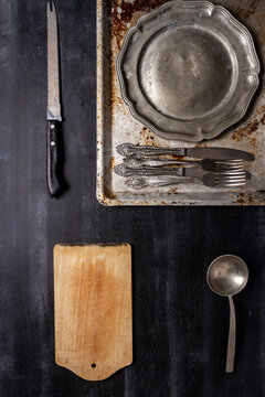 Old kitchen utensils on black chalkboard background.