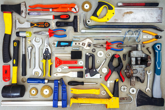 Flat lay of old and new hand tools on concrete background.