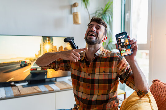 Man laughing playing video game missing work and boss calling