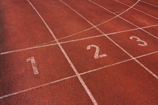  Athlete running track with number on the start . Perspective wide angle