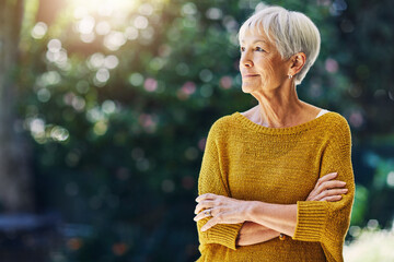 Fototapeta na wymiar Garden, thinking and senior woman with morning for reflection, nostalgia and daydreaming outdoor. Retirement, weekend and old person in nature with bokeh for space, memory and relax with arms crossed
