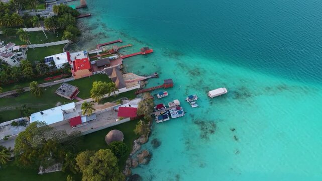 Private piers extend into shallow turquoise water from a vibrant green shore.