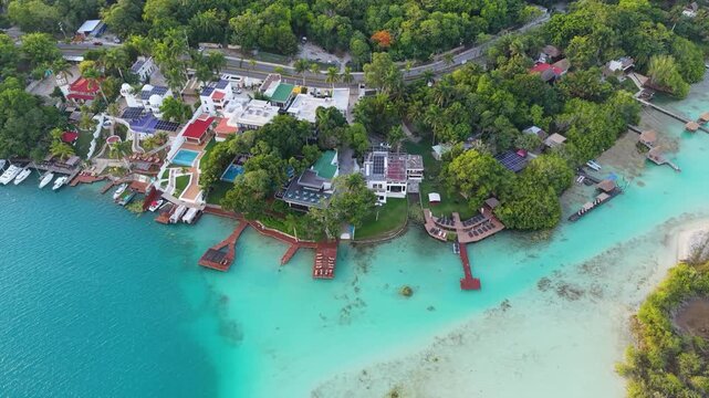 Private piers extend from green coastal lawns into bright aquamarine shoals.