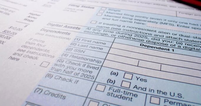 Federal tax return forms with red pen. USA tax form 1040 sheets fill frame beside red pen. Income tax paperwork appears ready for completion with visible fields check boxes and filing sections.