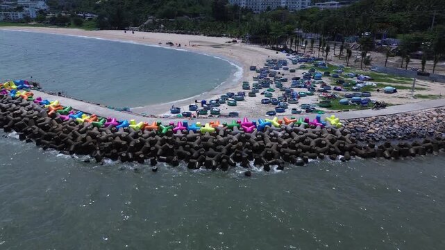 Cinematic aerial drone footage highlighting colorful coastal wave breakers and traditional round basket boats docked along the scenic beach in Mui Ne, Vietnam.