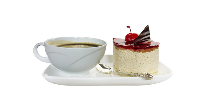 Elegant white cup of black coffee served alongside a slice of cherry-topped mousse cake and a silver spoon on a platter, isolated on black