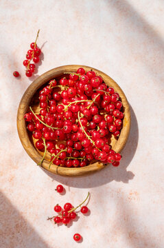 Fresh Red Currants in Wooden Bowl on Concrete Background in Warm Sunlight