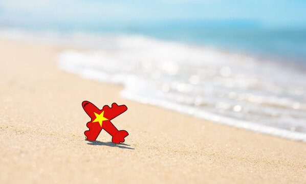 Vacation on the coast of Vietnam. Airplane in the colors of the flag of Vietnam on the seashore