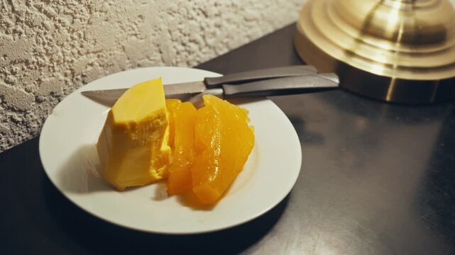 A close up camera push in displays a plate of traditional postre queso con dulce de batata. This visual is perfect for South American culinary videos and cultural food documentaries.
