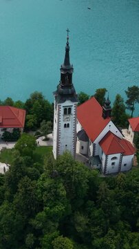 Vertical Drone Shot of Church Tower on Small Island in Lake Bled, Slovenia, Tourist Attraction and Landmark