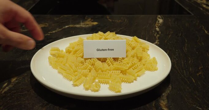 Close-up of gluten-free pasta on a plate with a label, representing dietary choices, food intolerance and special nutrition.