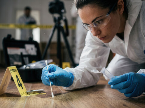 Forensic Scientist Collecting Evidence At A Crime Scene With Caution