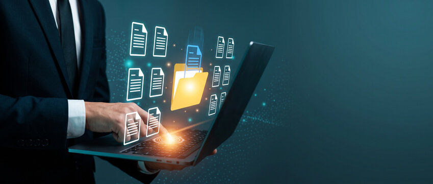 Business professional using a laptop with virtual document and folder icons floating above the keyboard, organizing digital files in an electronic document management system, document management, digi